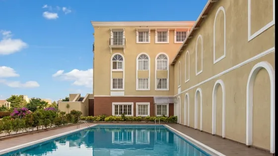 Swimming pool alongside the arched clubhouse wing at JRC Palladio