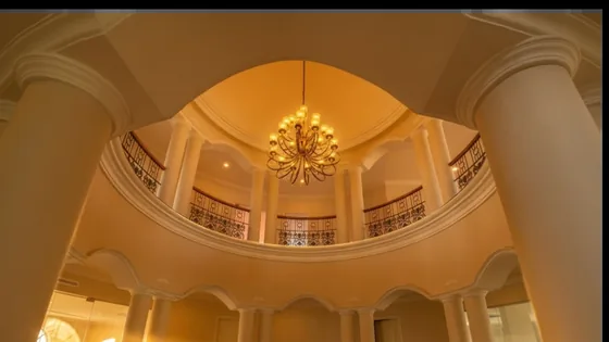 Double-height clubhouse rotunda with chandelier and colonnaded gallery
